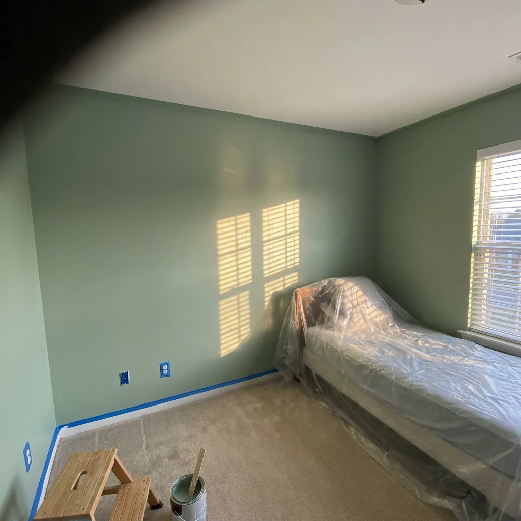 Las Vegas bedroom freshly painted in soft sage green with masked trim and outlets